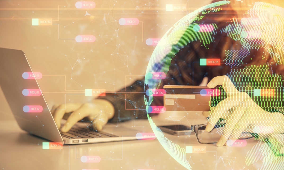 Double exposure of woman on-line shopping holding a credit card and world map hologram drawing. International E-commerce concept.