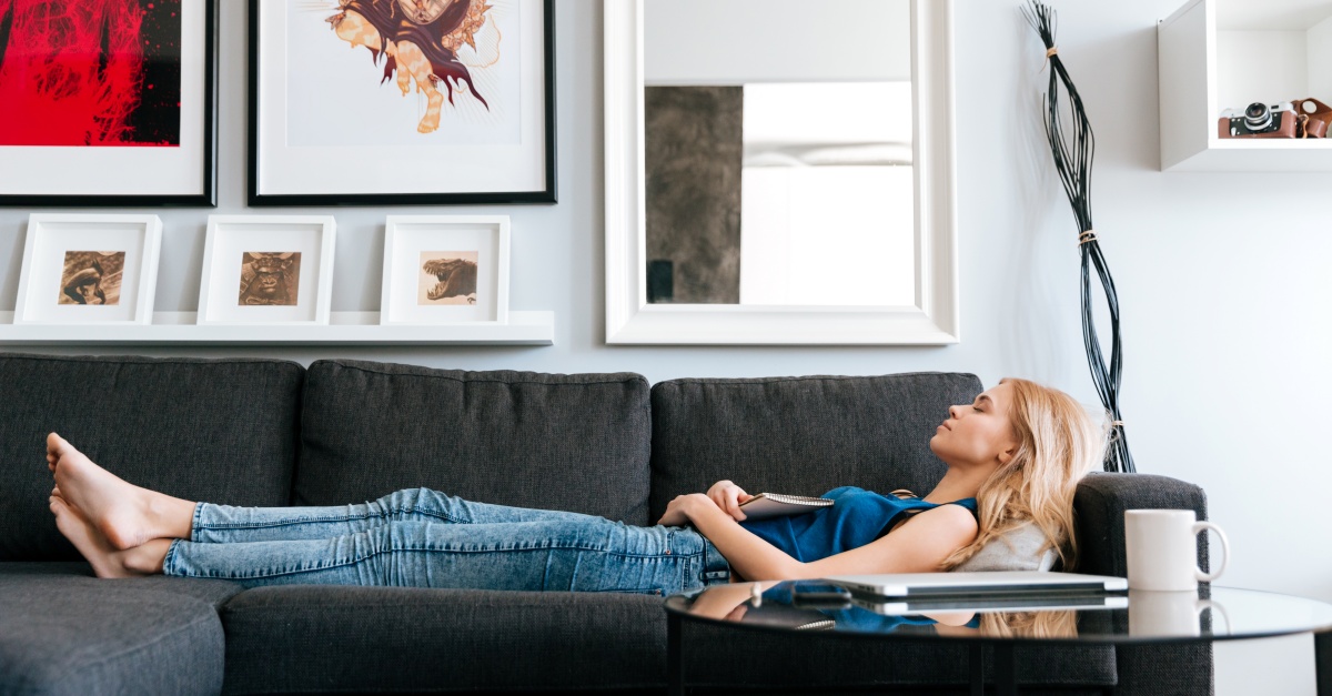 Woman lying and sleeping on sofa at home